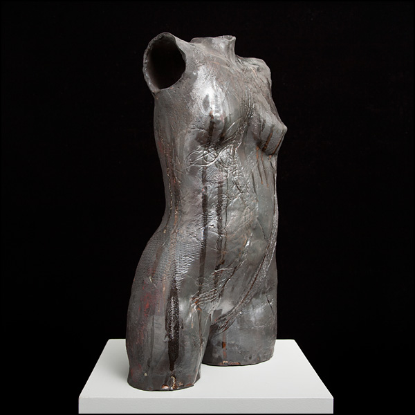Torso. Black stoneware clay with imprints. Glazes poured over. Approx 50cm tall, for in or outdoor display.